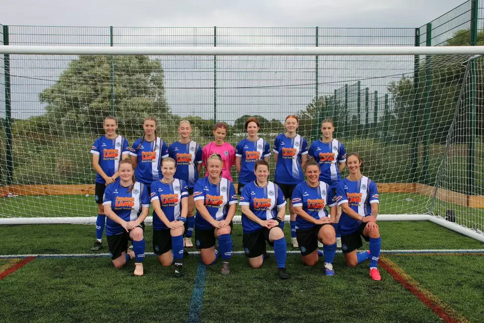 Pickering Town Ladies first team lined up in front of a goal, in the club's blue kit with the goalkeeper in pink